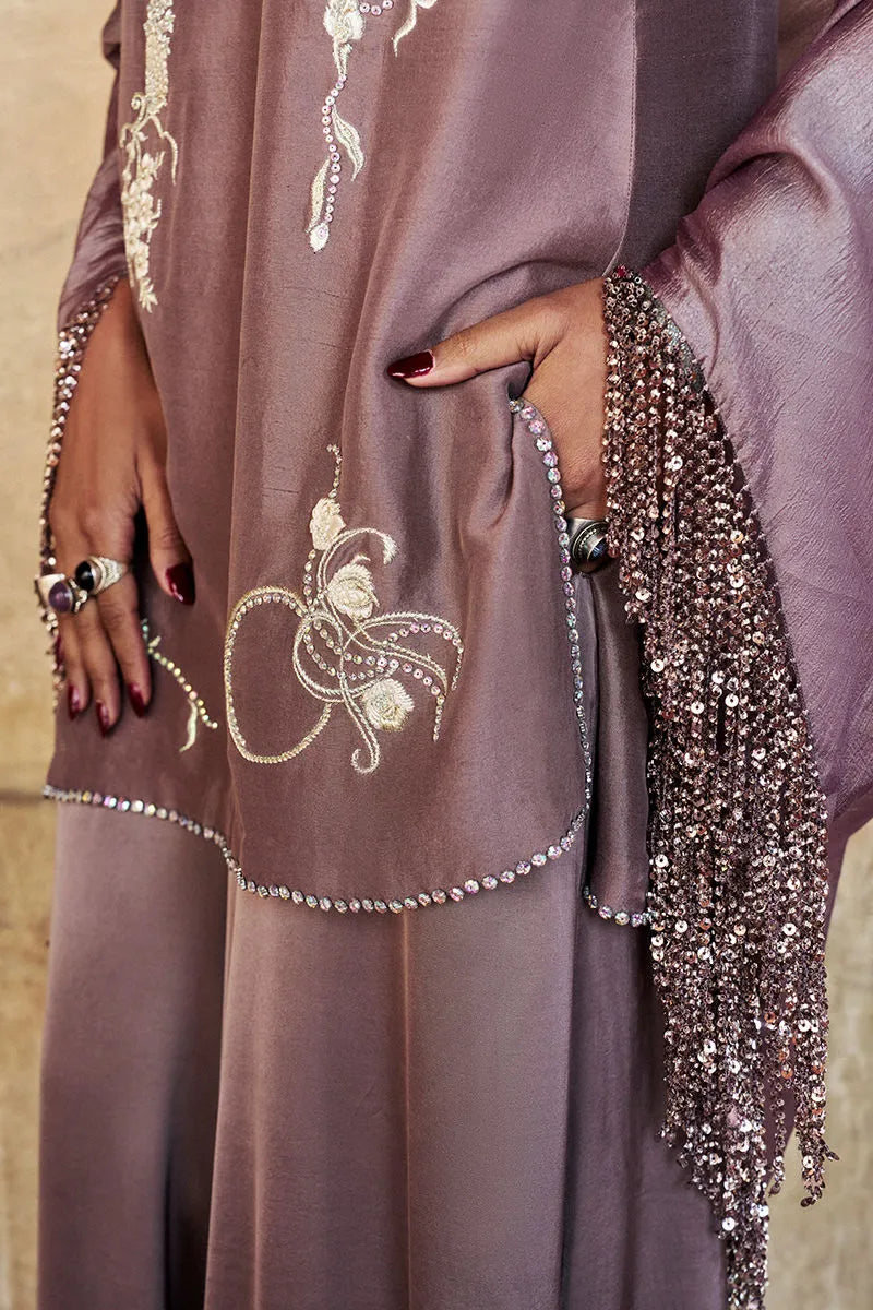Close-up of a mauve dress with intricate beadwork and embroidery.