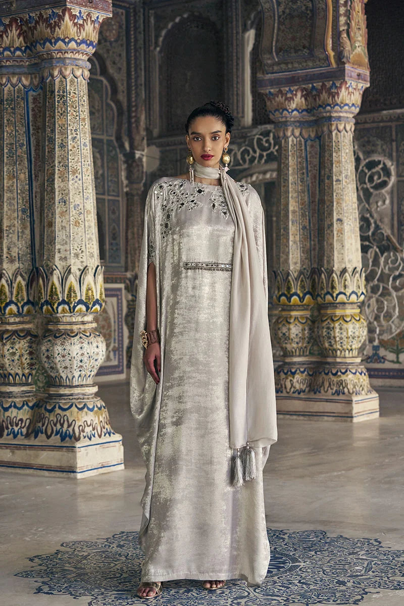Woman in a traditional outfit standing in an ornate indoor setting
