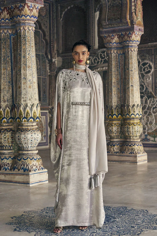 Woman in a traditional outfit standing in an ornate indoor setting
