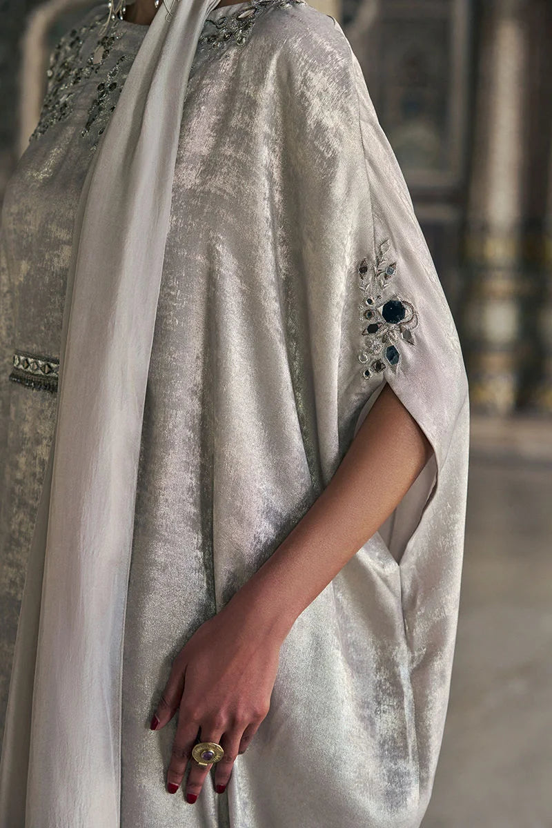 Close-up of a person wearing a light-colored garment with intricate detailing.