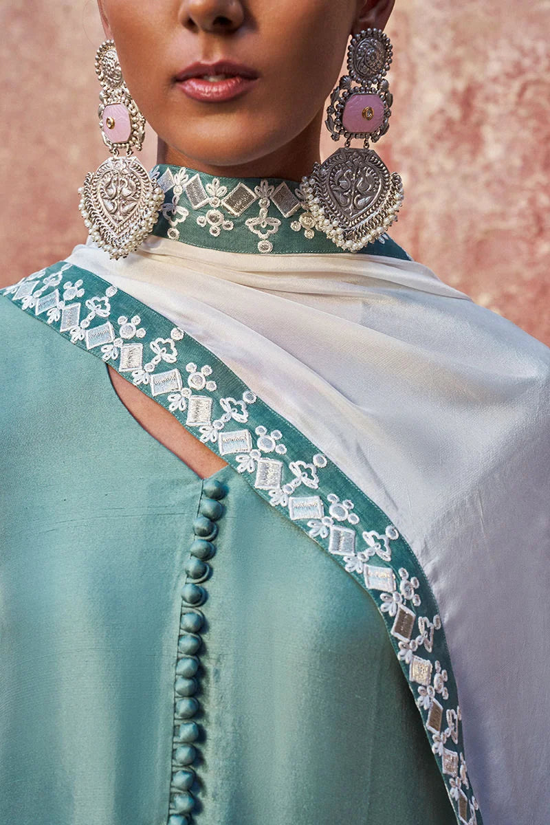 Close-up of a person wearing a traditional outfit with intricate embroidery and jewelry.