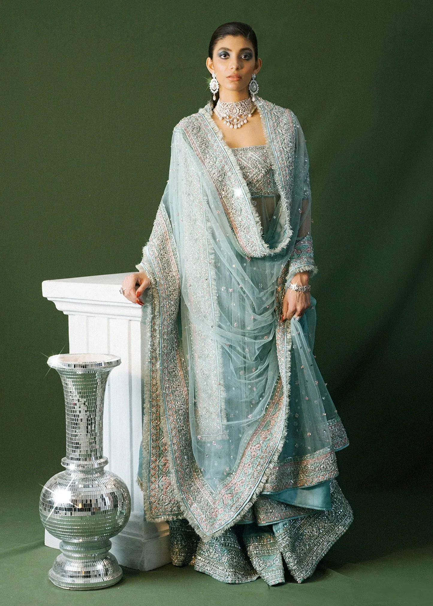 Woman in traditional attire with a green background