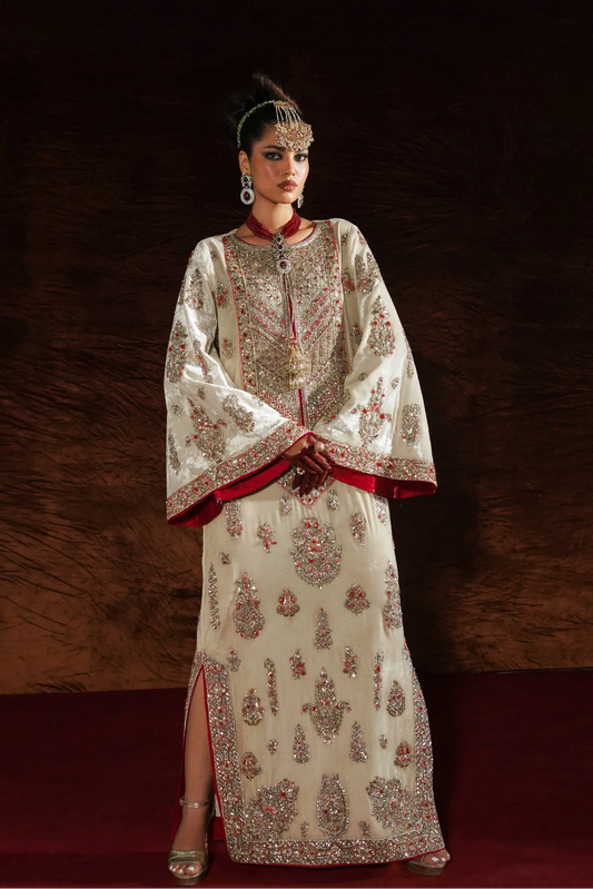 Woman wearing an ornate traditional outfit with intricate patterns against a dark background