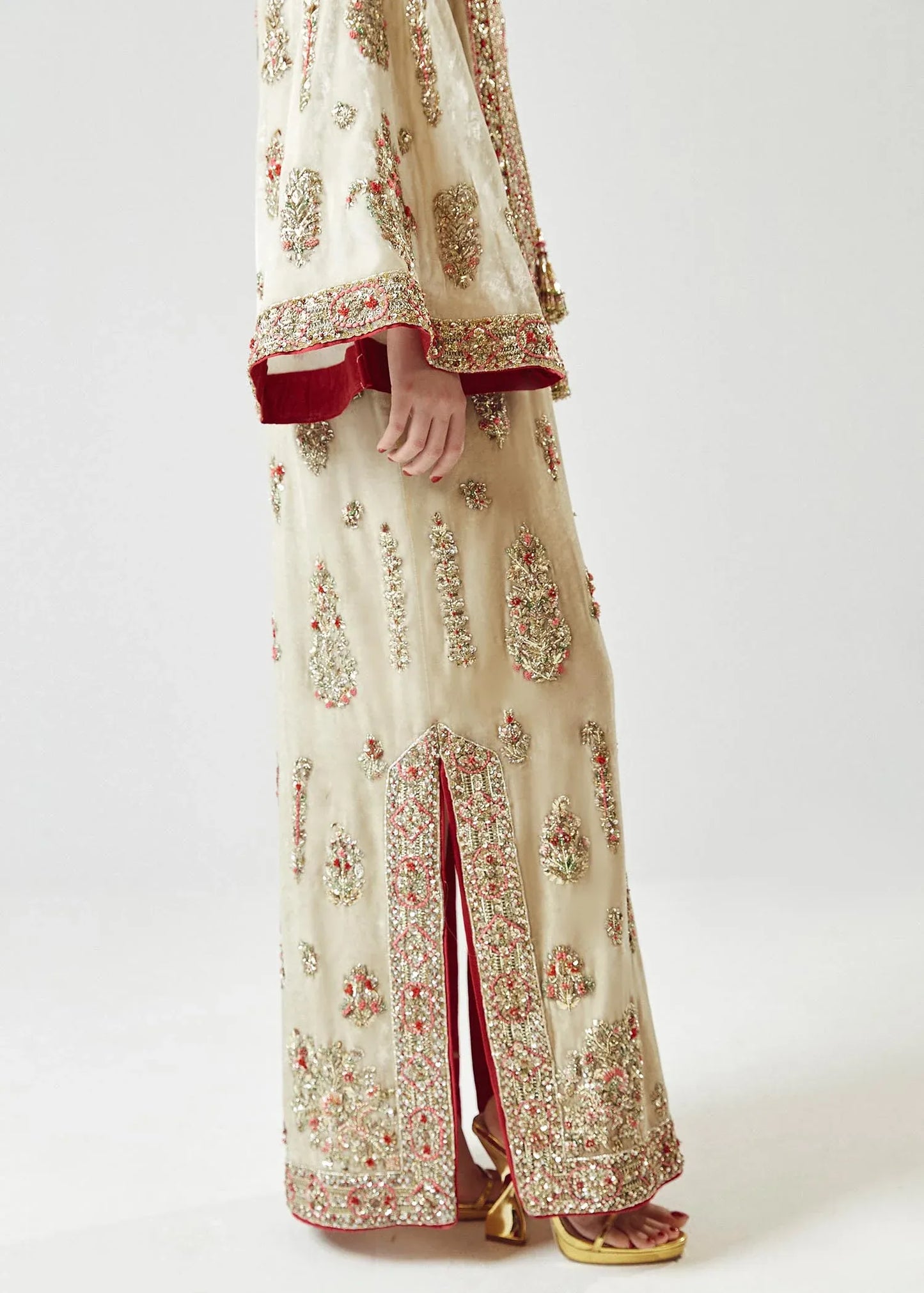 Traditional outfit with floral patterns and red accents on a white background