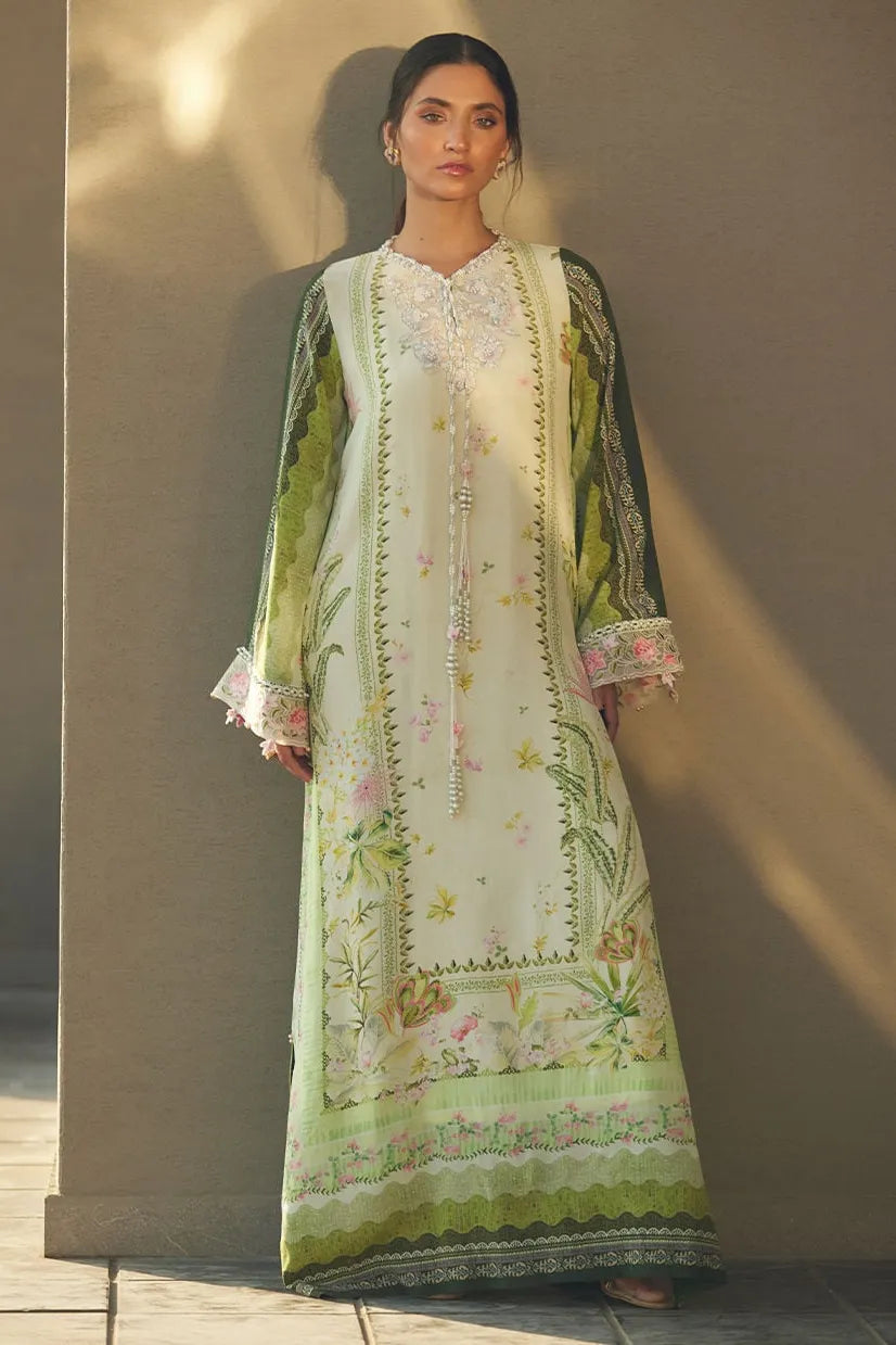 Woman wearing a floral embroidered dress with a green border against a neutral background