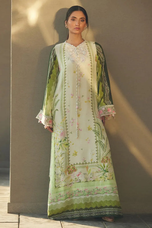 Woman wearing a floral embroidered dress with a green border against a neutral background