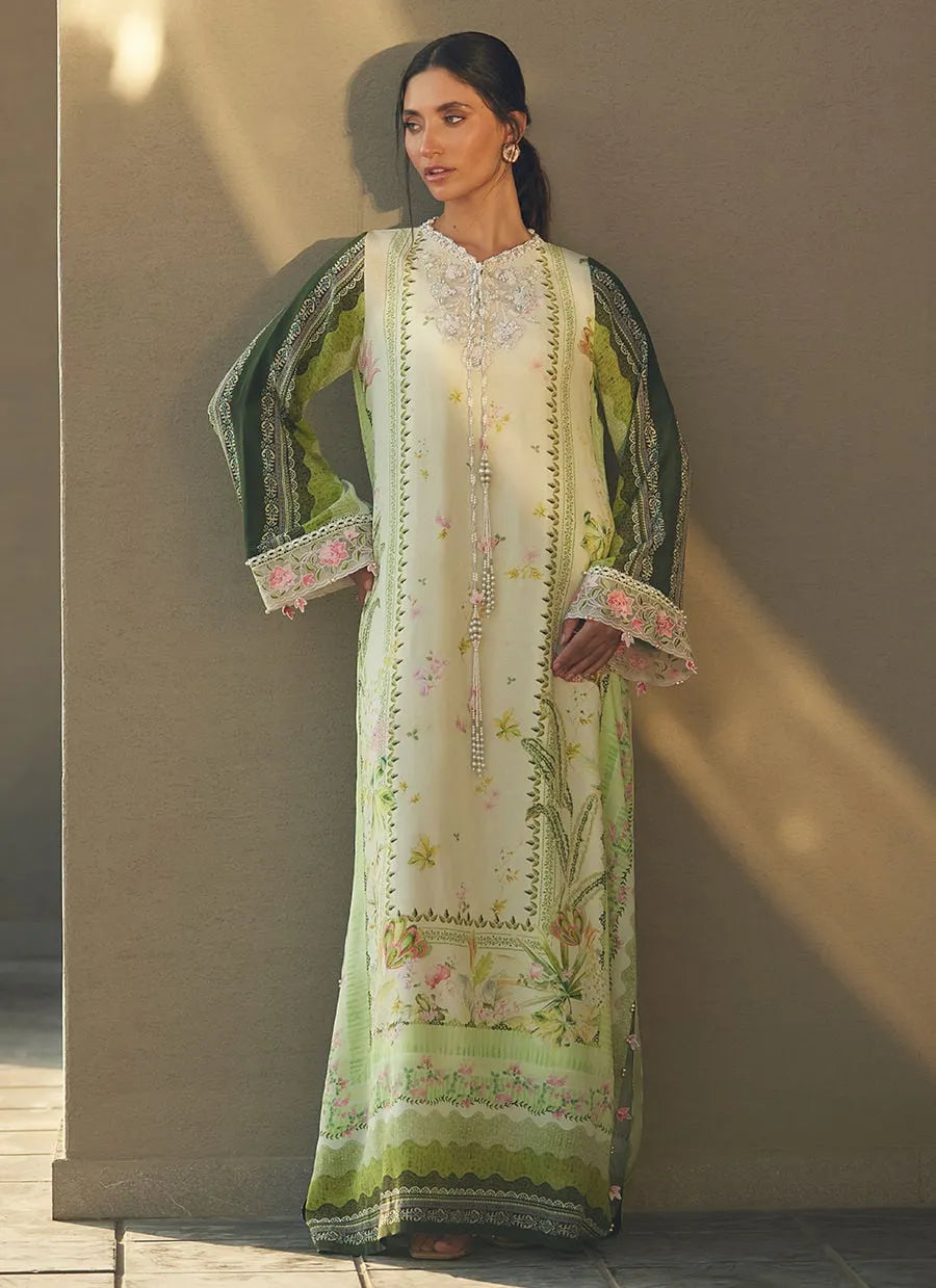 Woman wearing a long, embroidered dress with floral patterns against a neutral background