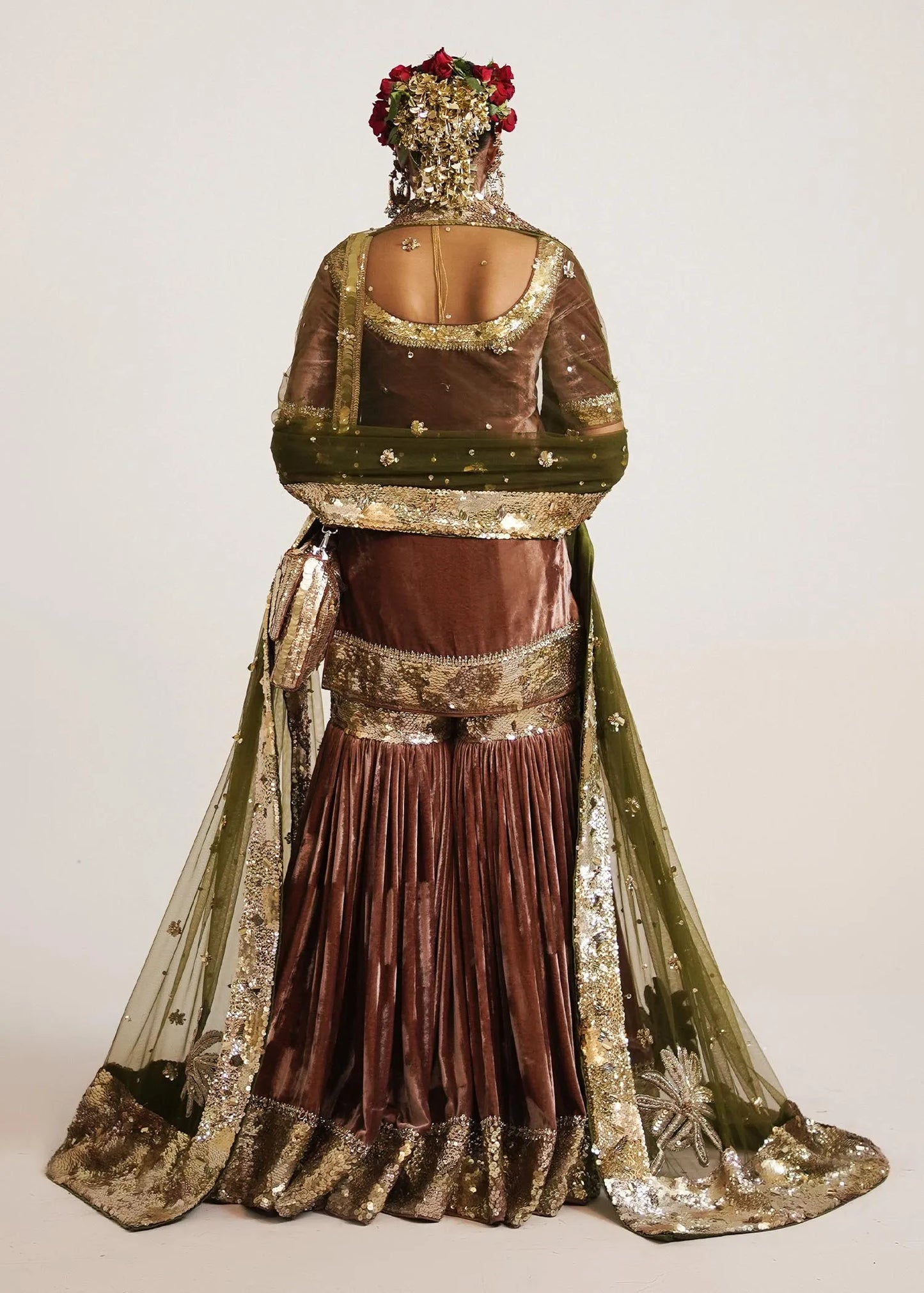 Traditional outfit with gold and brown details on a plain background