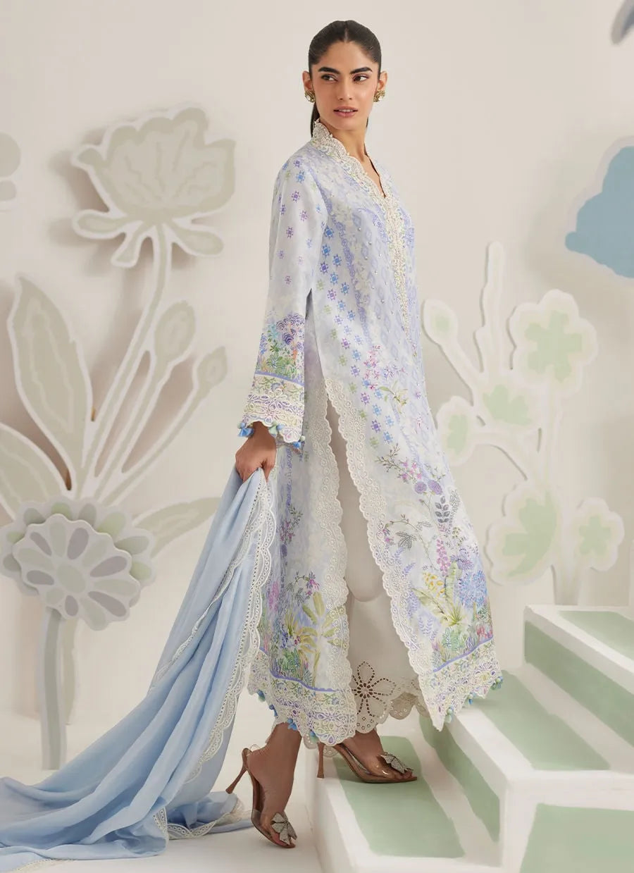 Woman in a floral dress standing on a decorative staircase with floral designs.