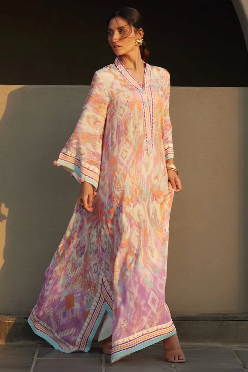 Woman wearing a long, patterned dress against a neutral background