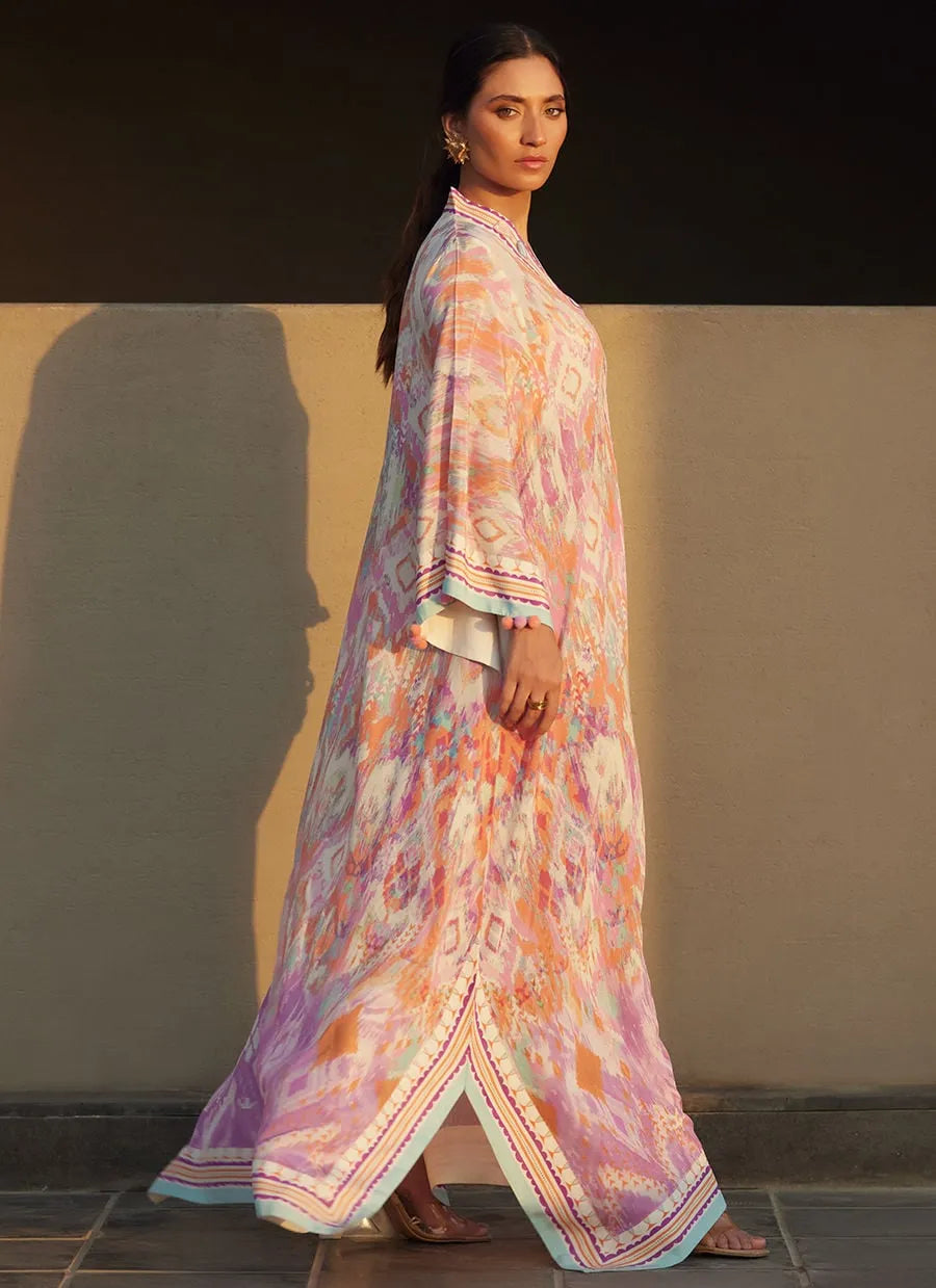 Woman wearing a colorful traditional outfit against a neutral wall.