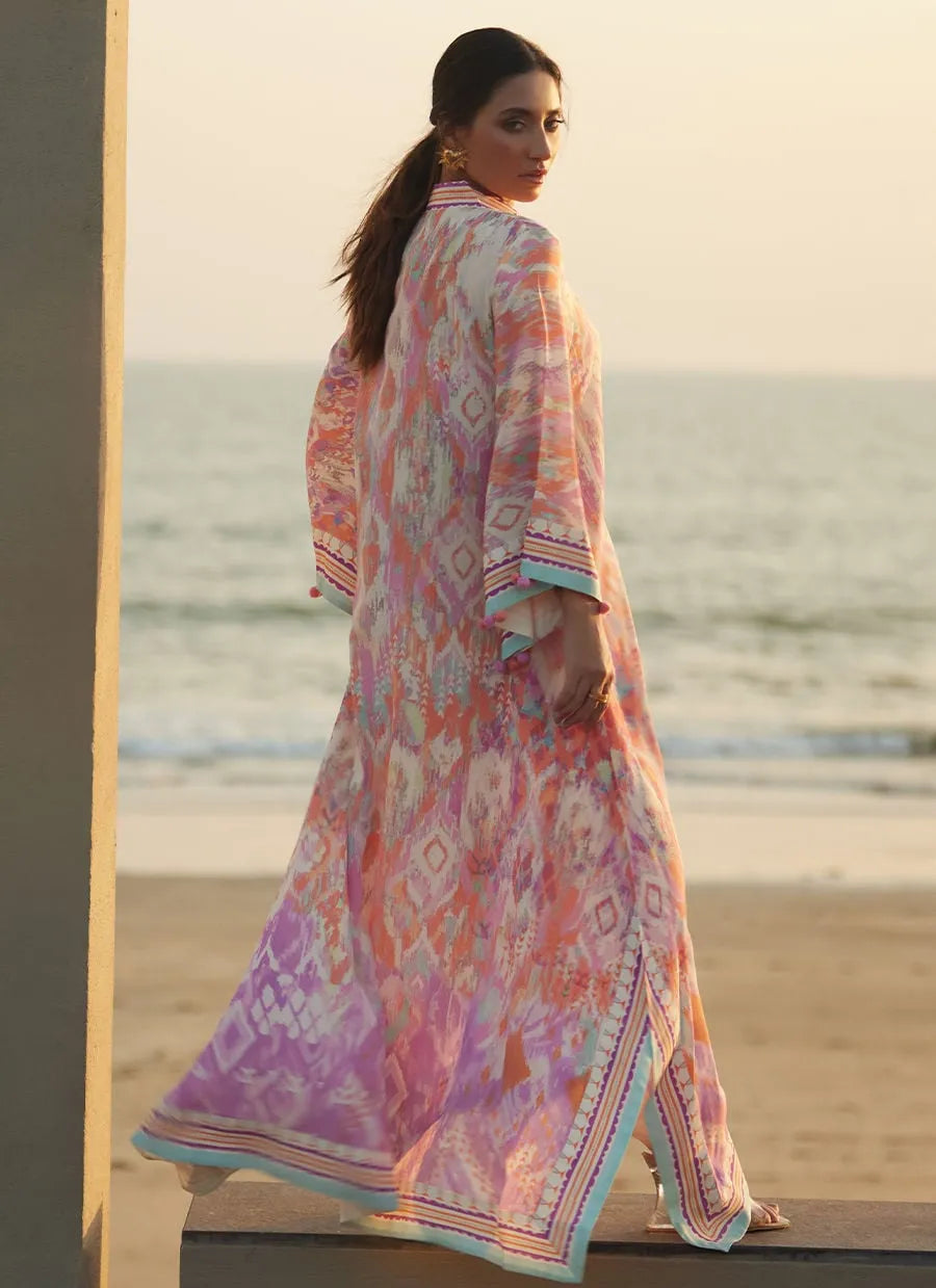 Woman in a colorful dress standing on a beach with ocean view