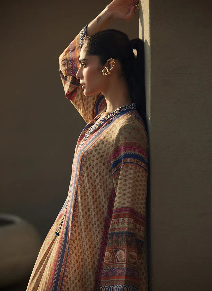 Woman in a patterned outfit standing against a wall with warm lighting