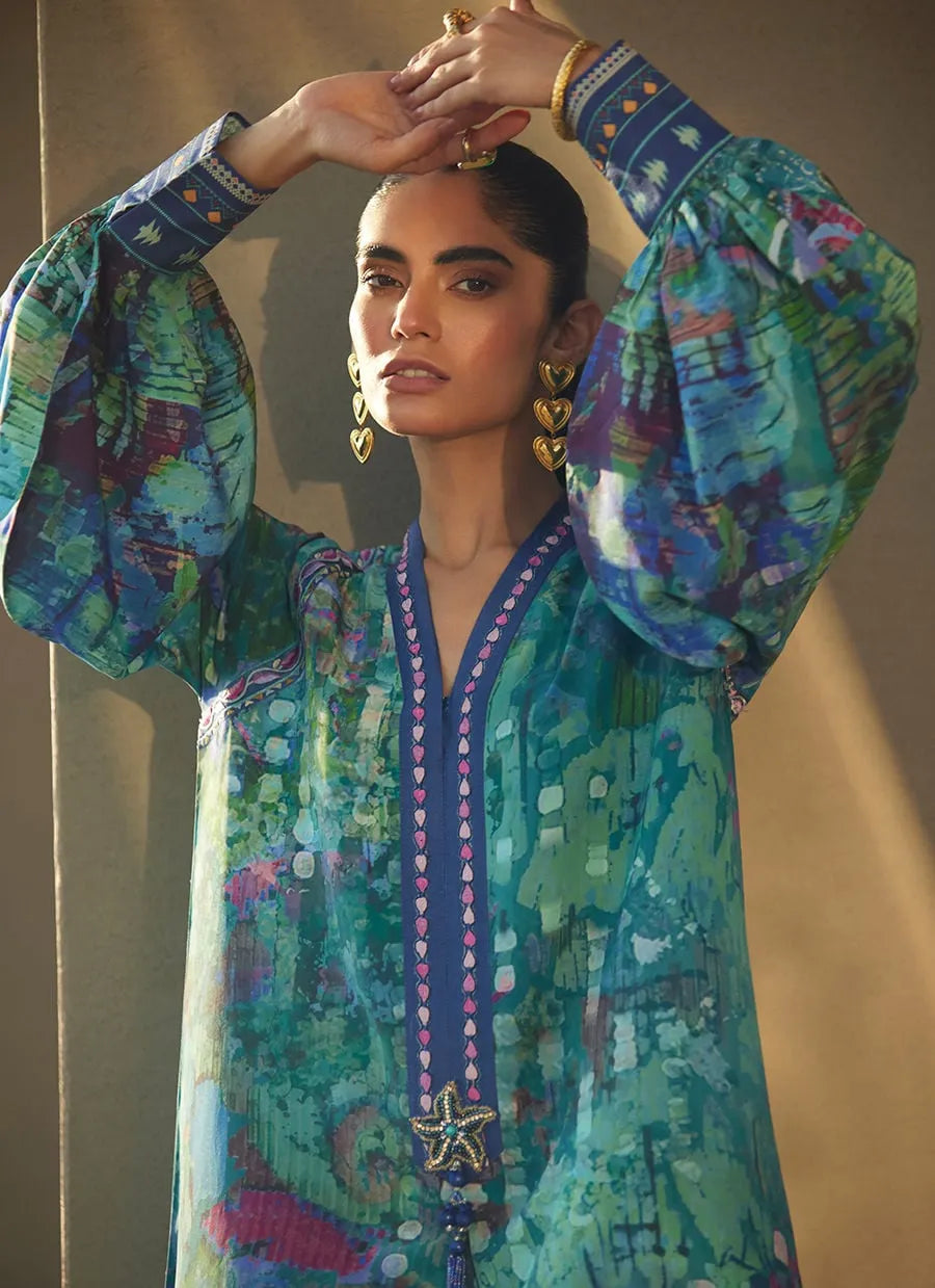 Woman wearing a colorful traditional outfit with intricate patterns and jewelry against a neutral background