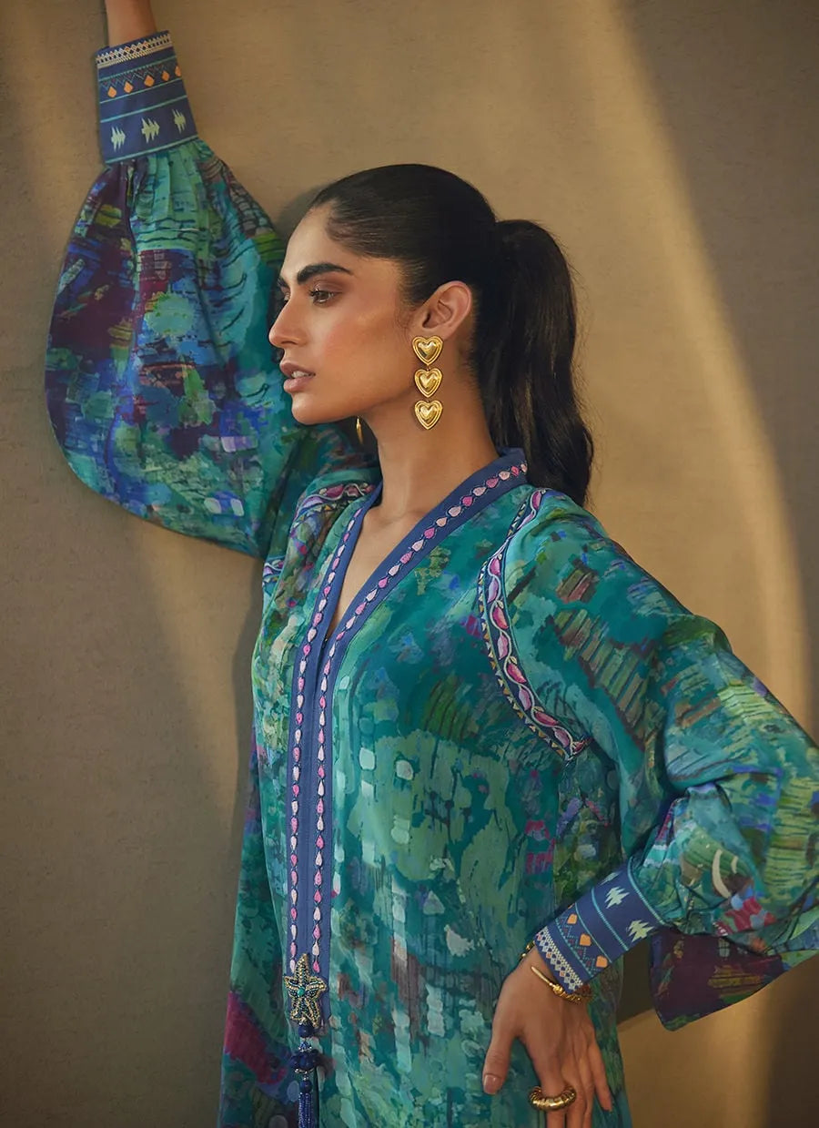 Woman wearing a colorful traditional outfit with intricate patterns and jewelry against a beige background