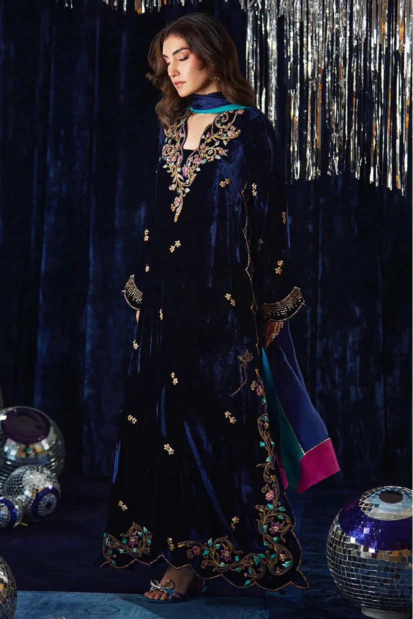 Woman in a dark blue embroidered outfit with a festive background