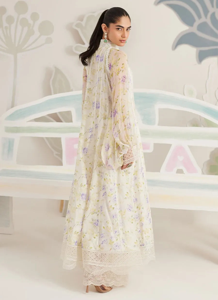 Woman wearing a floral dress standing in front of a decorative wall.