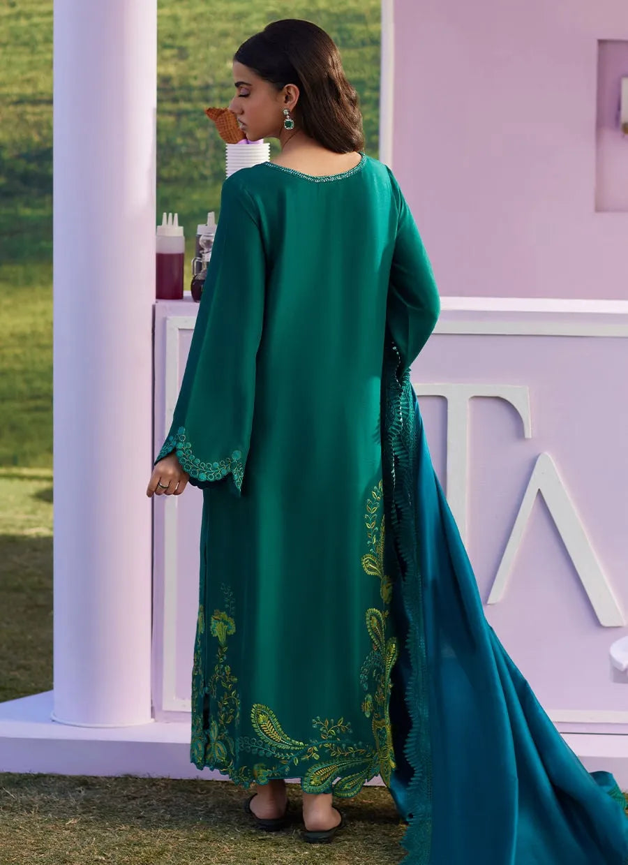 Woman wearing a green embroidered dress with a blurred background