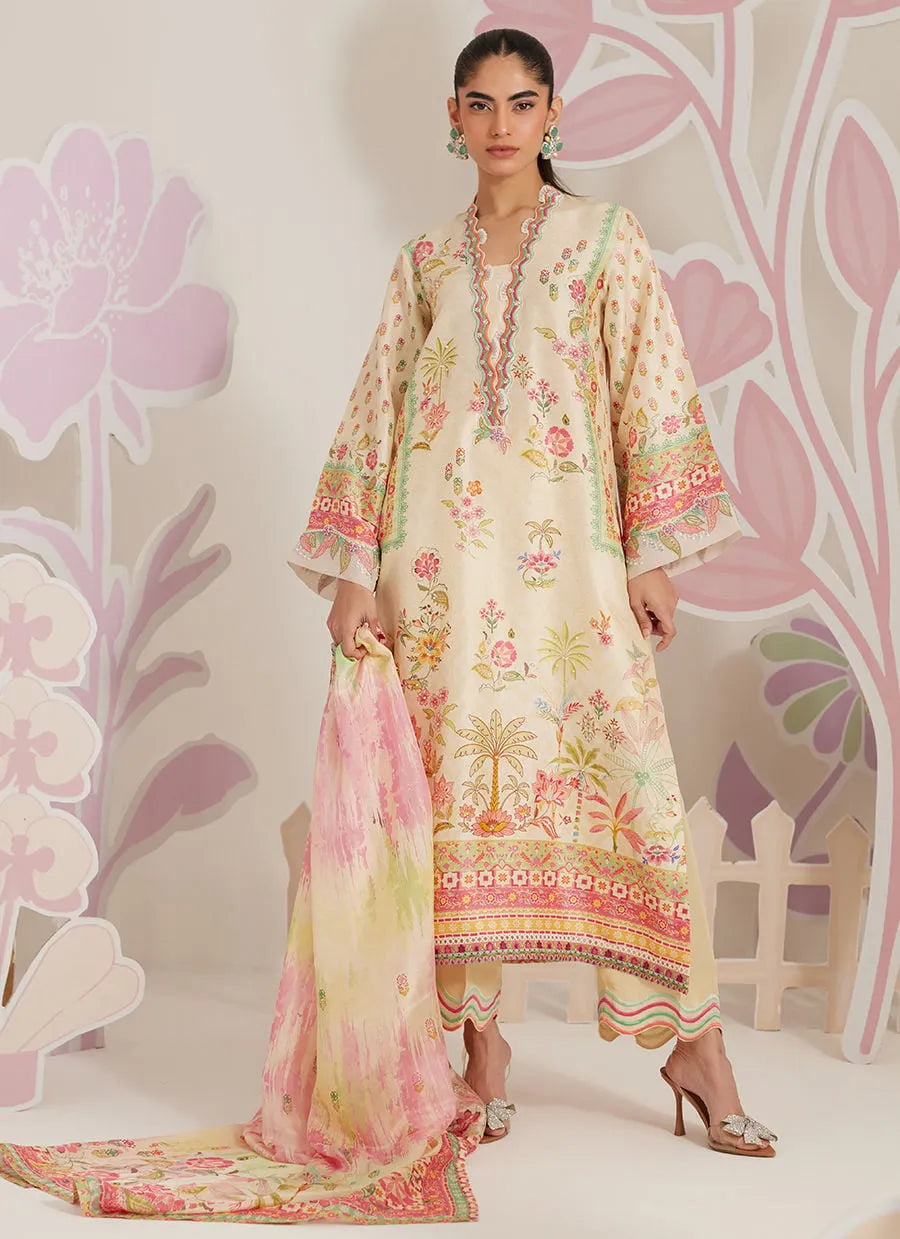 Woman wearing a floral dress with a matching dupatta against a decorative pink background