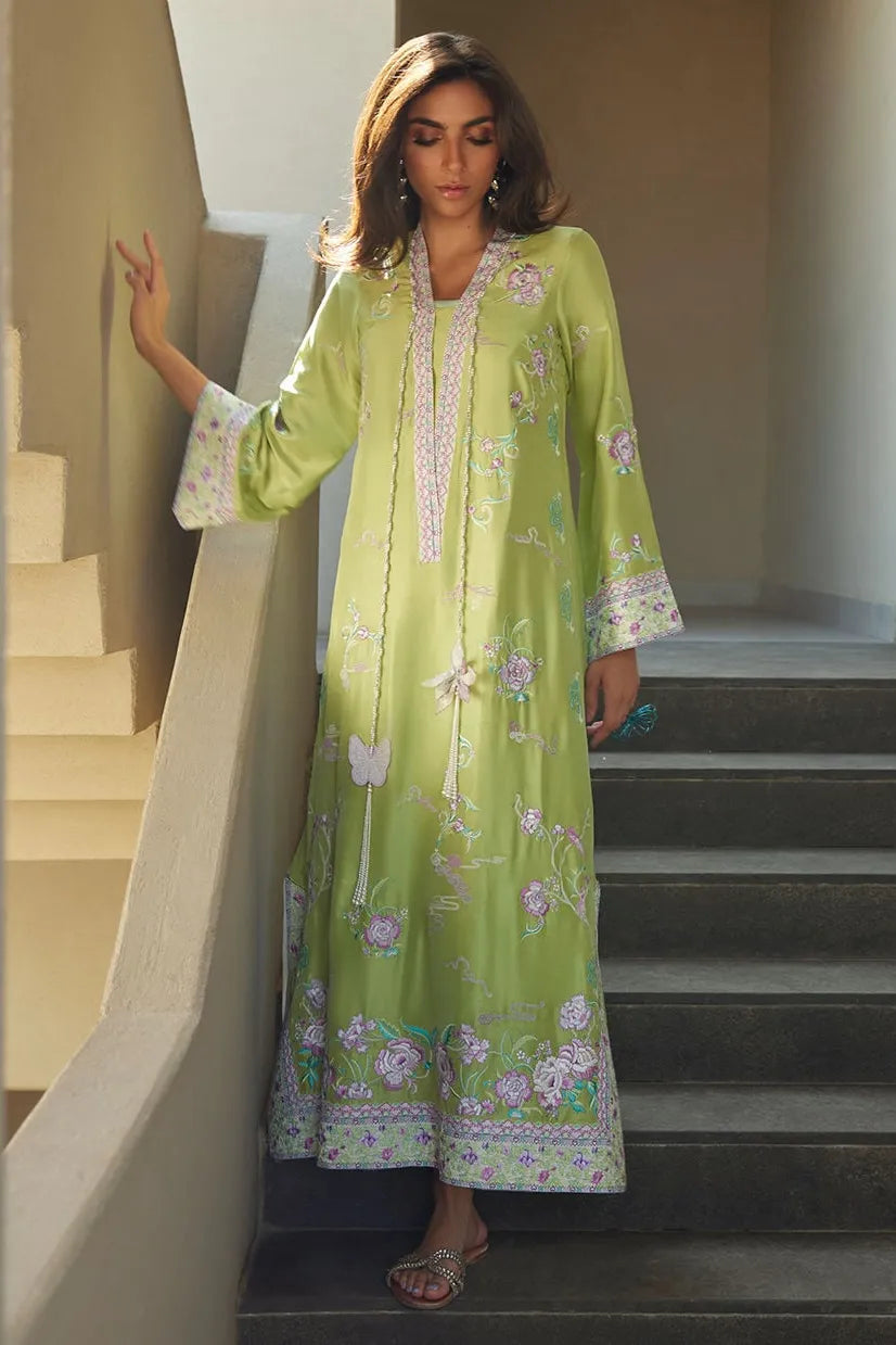 Woman in a green floral dress standing on a staircase