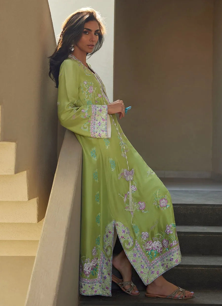Woman in a green floral outfit standing on a staircase.
