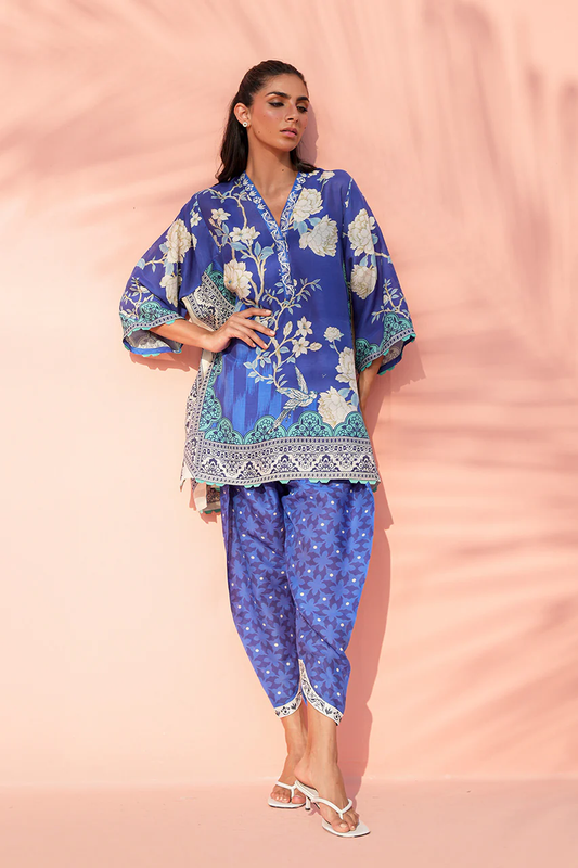 Woman wearing a blue floral outfit on a pink background